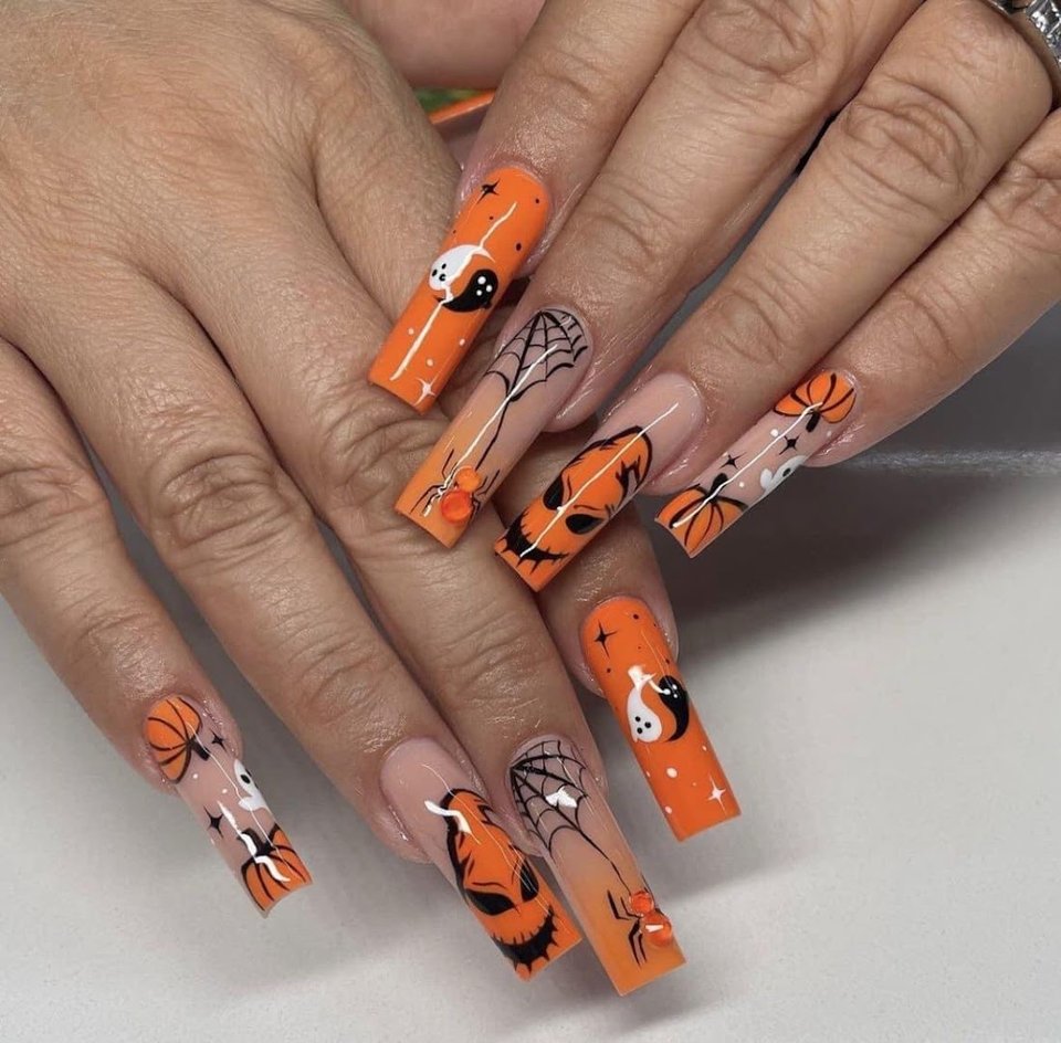 Nail technician shaping acrylic nails at a salon table.